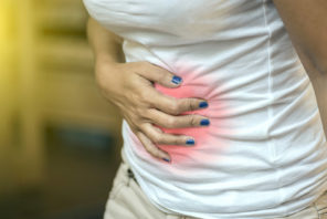 a woman gripping her stomach in pain